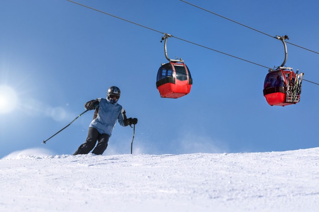 Skieurs dévalant les pistes de Courchevel sous un ciel bleu